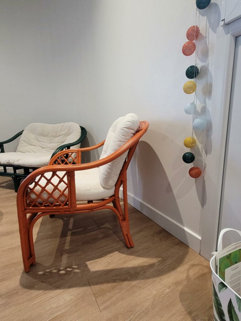 Coin d’accueil du cabinet Révèl’Coaching avec fauteuil et décoration murale