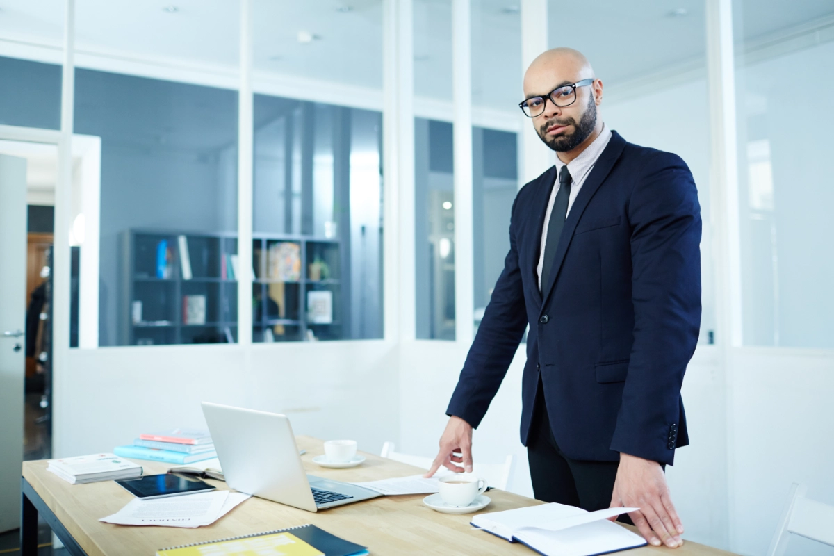 Professionnel debout devant un bureau dans un environnement de travail en entreprise